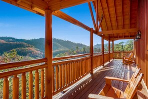 A wooden deck with a view of a forested valley. - Paradise Pointe Pool Lodge by Beyond Expectations (Sevierville)