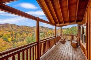 A wooden deck with a view of autumn foliage. - Paradise Pointe Pool Lodge by Beyond Expectations (Sevierville)