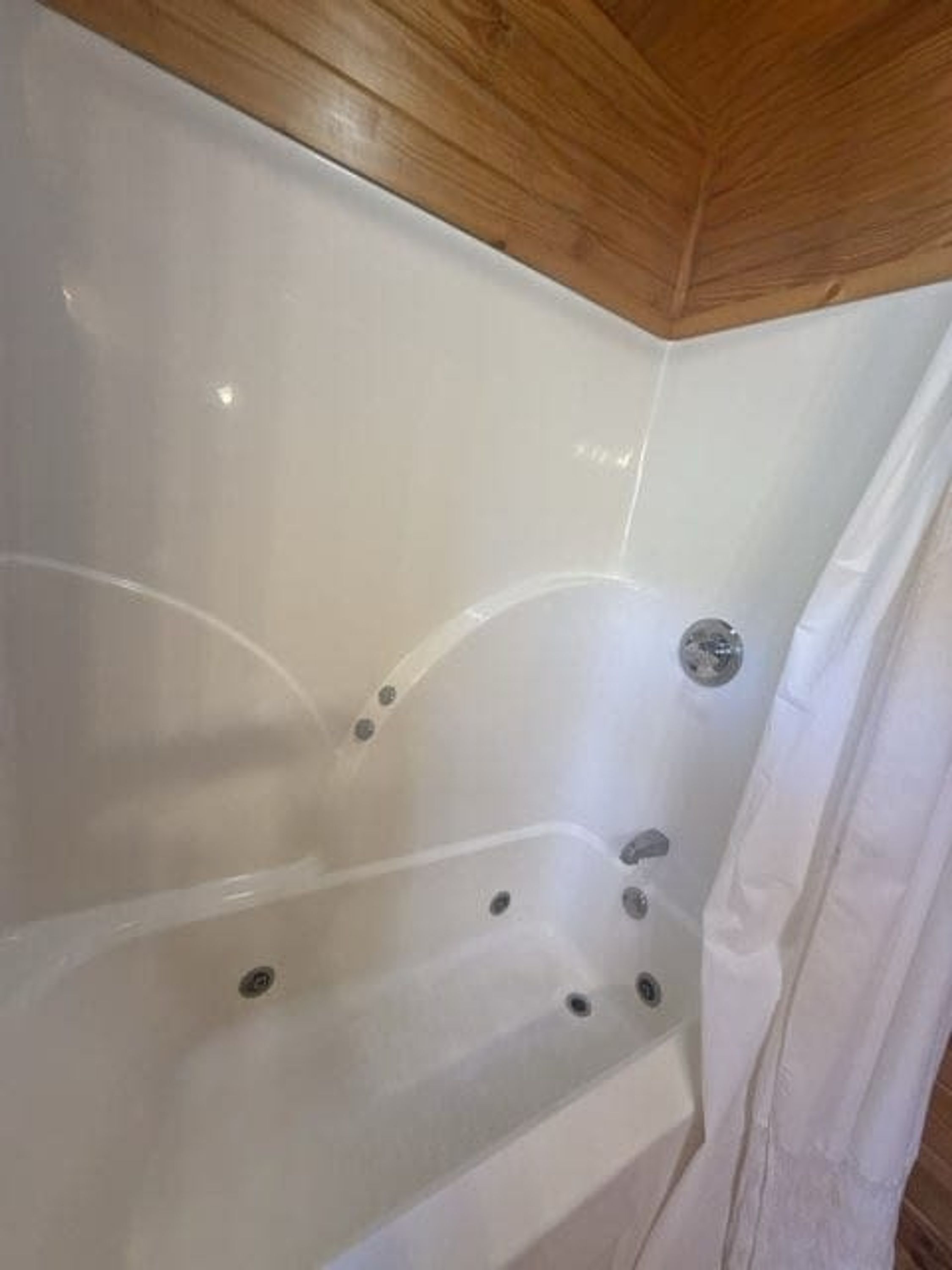 Une baignoire avec un plafond en bois.