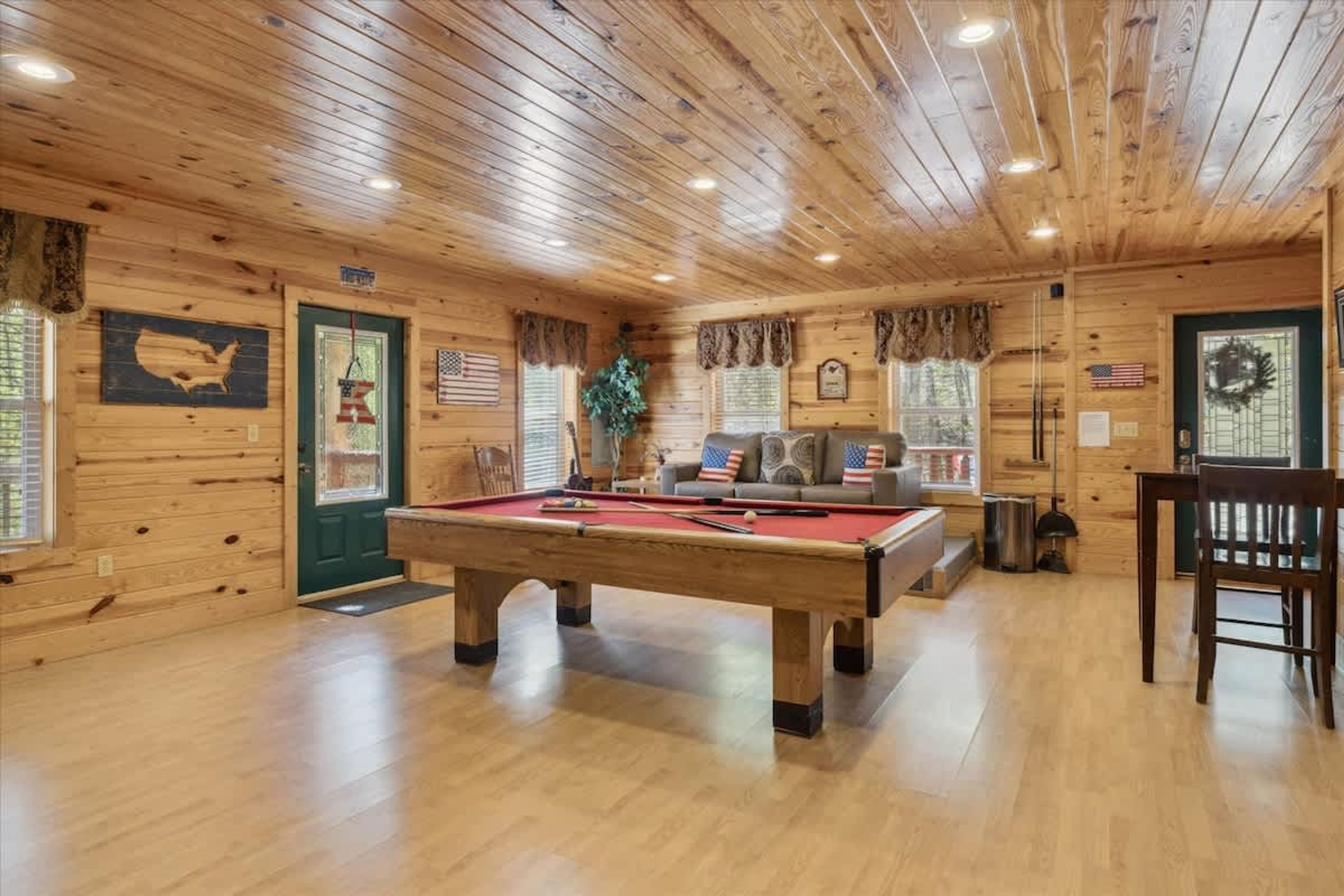 Un interno in legno con tavolo da biliardo, divano e tavolo da pranzo.