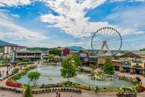 A park with a large Ferris wheel, a fountain, and various buildings including a restaurant. - Rise n Shine Cabin by Beyond Expectations With Hot Tub (Sevierville)