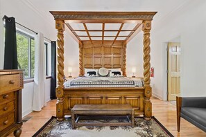 A four-poster bed with a wooden frame and a bench at the foot. - Hideaway at the River by Beyond Expectations (Sevierville)