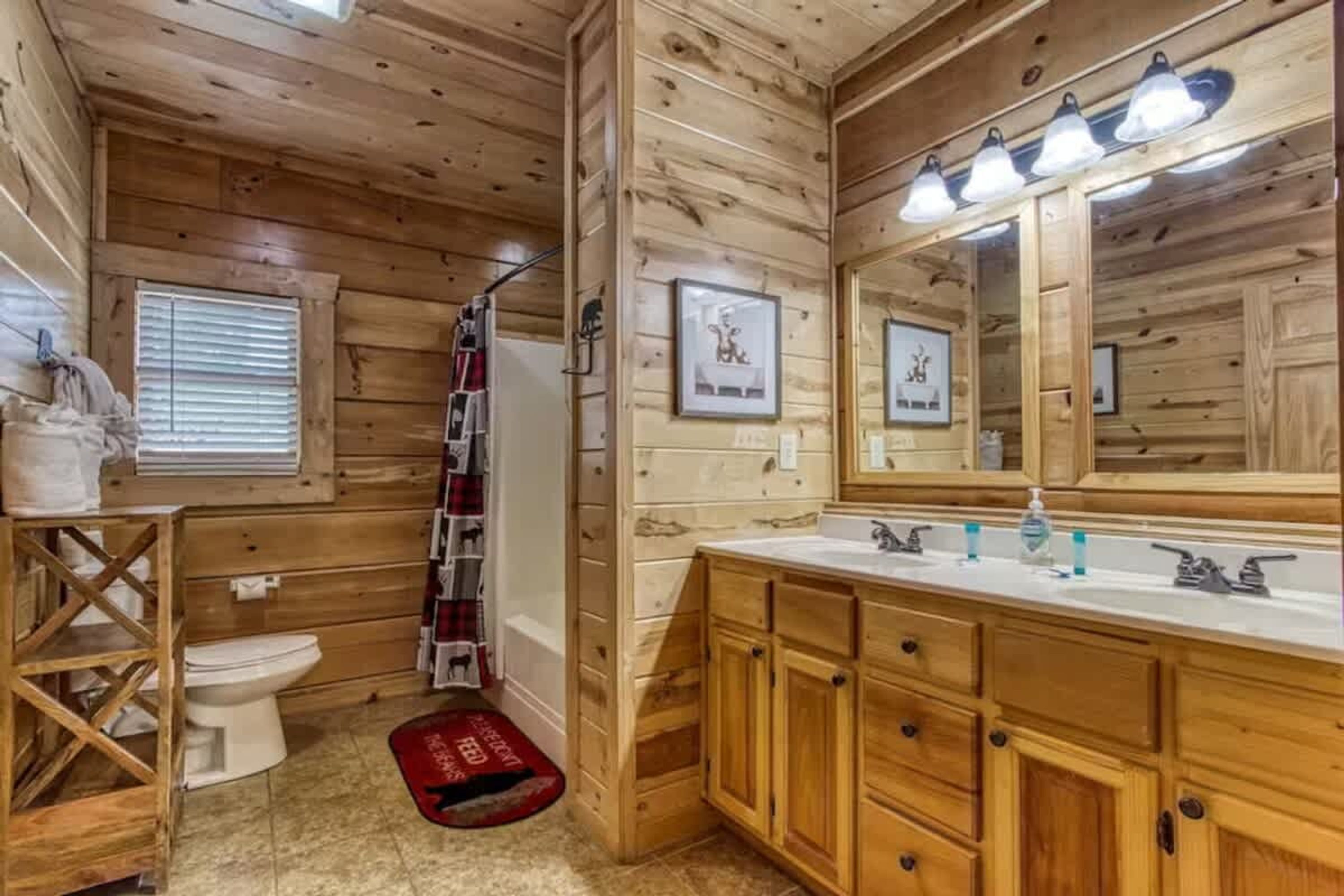 Baño de cabaña de madera con inodoro, lavabo y espejo.