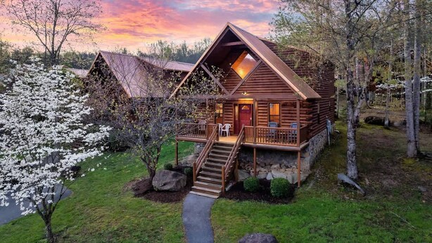 A log cabin with a balcony and a staircase leading to the entrance. - Dotties Place Cabin by Beyond Expectations With Hot Tub (Gatlinburg)