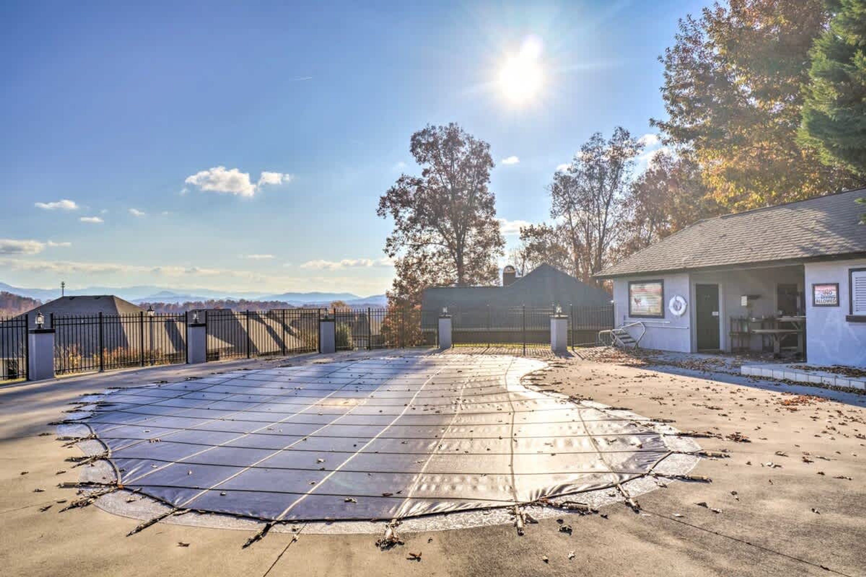 Un parking équipé d’une grande installation de panneaux solaires, doté d’une entrée sécurisée par une barrière et comprenant un bâtiment avec une enseigne.