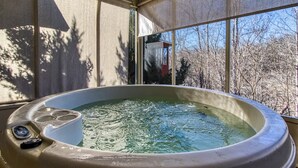 Un jacuzzi con vistas a árboles y un edificio al fondo.