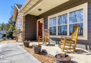 A house with a porch, two rocking chairs, and potted plants. - Saddleback Retreat by Beyond Expectations (Sevierville)