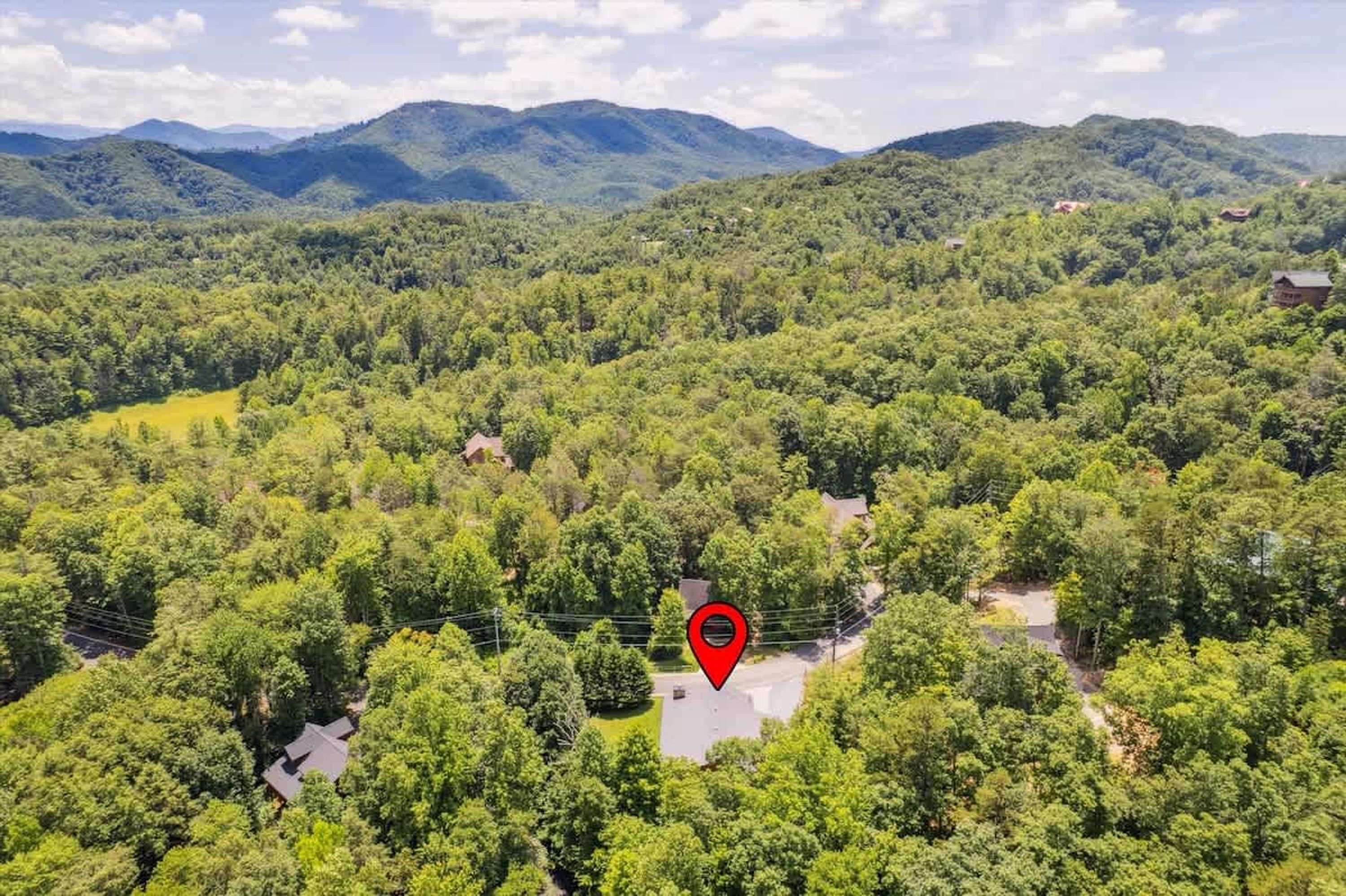 A forested area with a red pin marking a specific location.