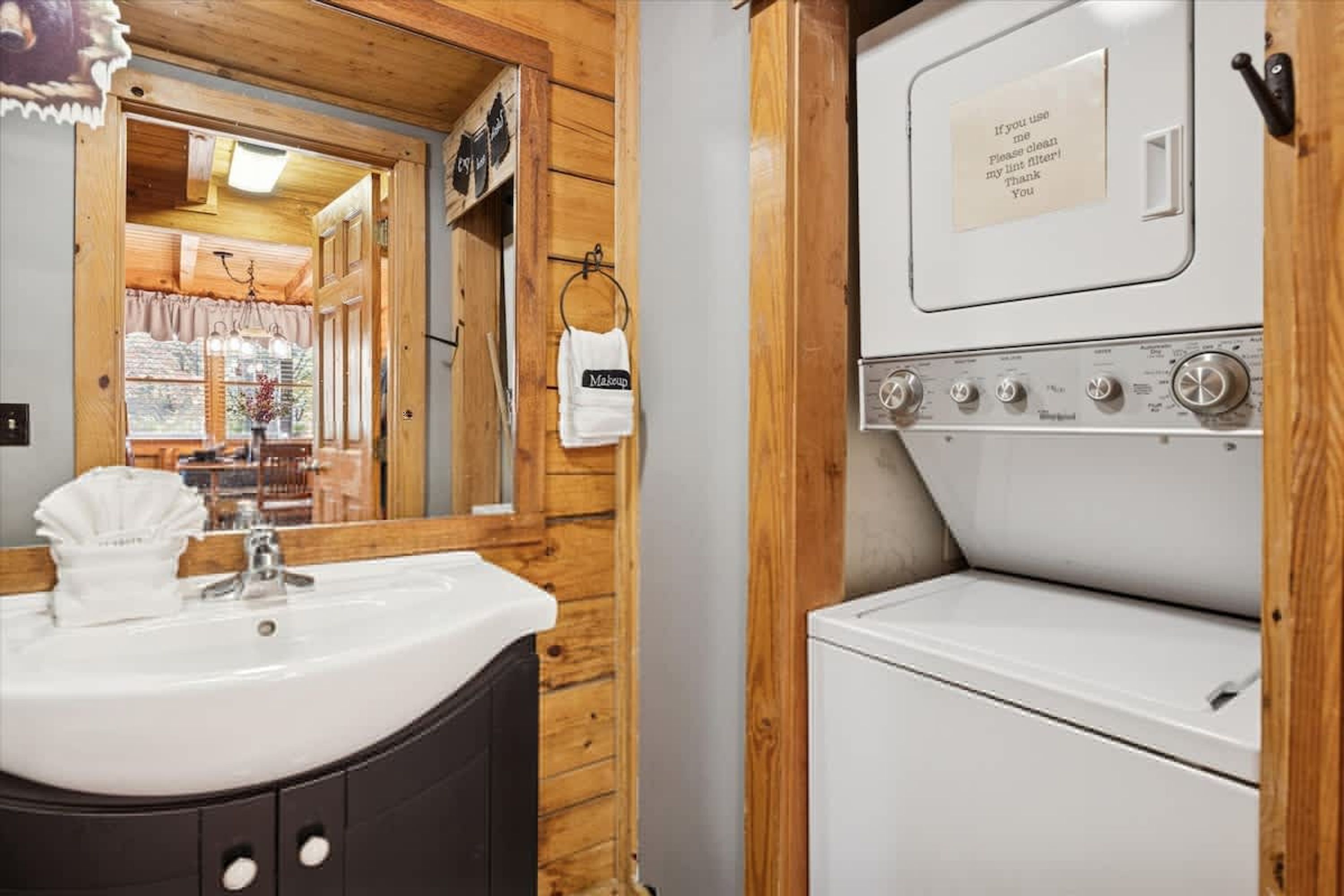 A bathroom with a wooden interior, a sink, and a washing machine.