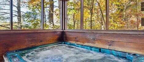 A hot tub with a wooden interior and large windows.