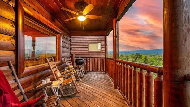 A wooden cabin with a balcony, a ceiling fan, and a view of the landscape. - Majestic Overlook II by Beyond Expectations (Sevierville)
