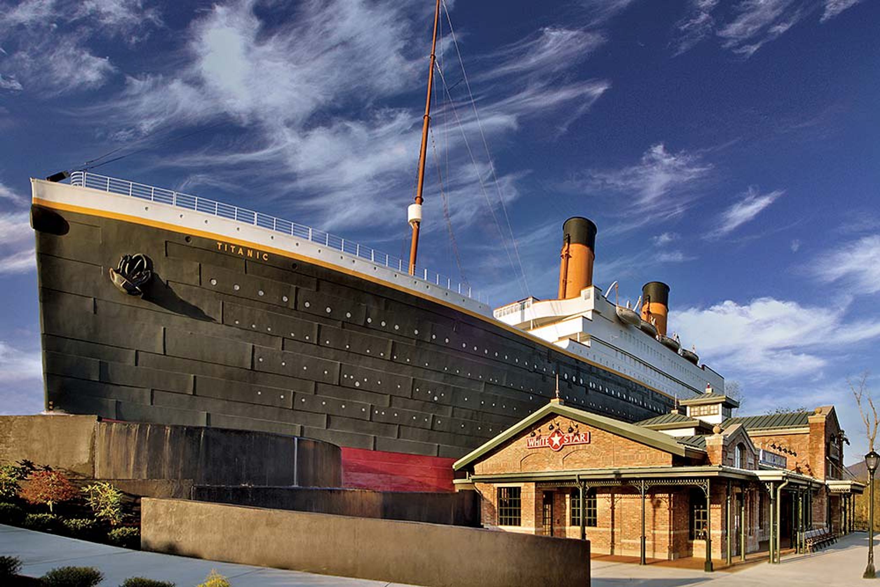 A large ship with the name 'TITANIC' and a building labeled 'WHITE STAR' in front of it.