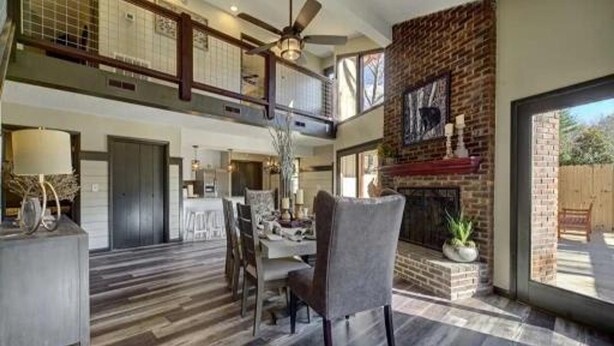 A spacious living area with a fireplace, a dining table, and a high ceiling with a fan. - Emmas Rare Find by Beyond Expectations Cabin With Hot Tub (Sevierville)