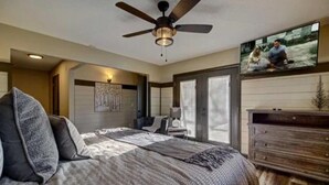 A bedroom with a bed, a ceiling fan, a TV, and a dresser. - Emmas Rare Find by Beyond Expectations Cabin With Hot Tub (Sevierville)