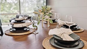 A dining table set with plates, glasses, and napkins. - Smoky Shores Lakeview Cabin by Beyond Expectations (Sevierville)