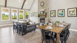 A spacious living area with a fireplace, dining table set for six, and a cozy seating area. - Mountain View Beauty by Beyond Expectations (Gatlinburg)
