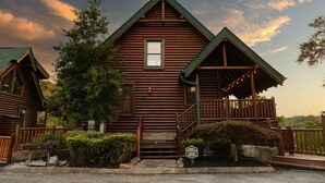 A wooden log cabin with a balcony, a window, and a sign indicating a family tradition. - Smoky Haven Retreat by Beyond Expectations (Sevierville)