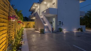 A modern multi-story building with a staircase leading to the upper floor, a flat roof, and a paved driveway. - Diana s House 4 - Gytheio Sandy Beach Haven (East Mani)
