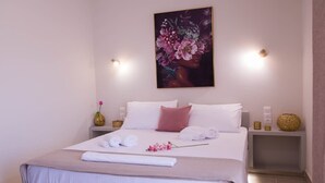 A neatly made bed with white and pink bedding, a painting above it, and two bedside tables with decorative items. - Diana s House 4 - Gytheio Sandy Beach Haven (East Mani)
