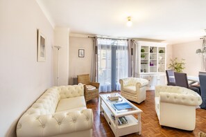 A living room with a sofa set, a coffee table, a wicker chair, and a bookshelf. - Holiday Home 'Sarloveze Centre De Sarlat' with Wi-Fi and Air Conditioning (Sarlat-la-Canéda)