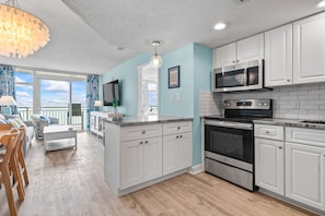 A modern kitchen with white cabinets, a stainless steel oven, and a microwave. - NEW Oceanfront Master 2bd/2ba Free Parking & WiFi (Myrtle Beach)