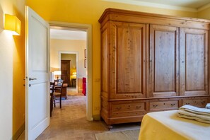 Ein Zimmer mit einem Bett, einem Holzschrank und einer Tür zu einem anderen Raum.