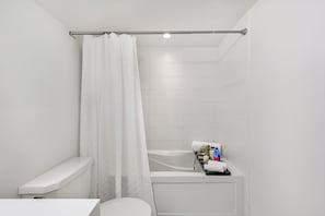 Ein modernes Badezimmer mit Toilette, Badewanne und Duschvorhang.