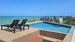 A rooftop pool with two lounge chairs and a view of the ocean. - Mare Nostrum - João Pessoa - Beira Mar  (João Pessoa)