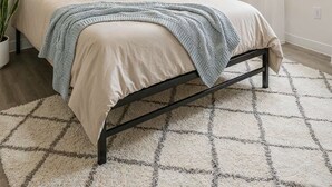A bedroom with a bed, a bedside table with a lamp, a window with curtains, and a painting on the wall. - Private Room in SE Austin - 10 min from Airport & Downtown (Austin)