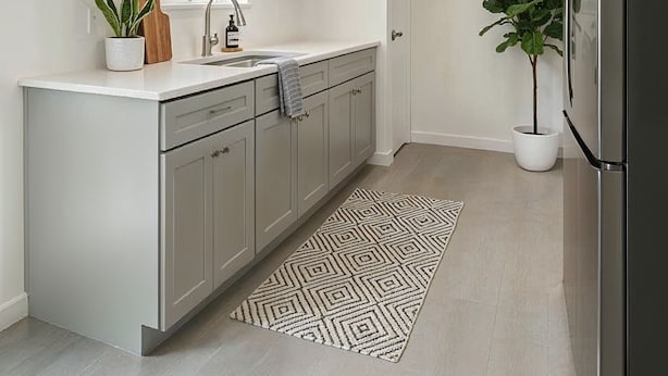 A modern kitchen with light grey cabinets, a stainless steel refrigerator, a sink with a faucet, a potted plant, and a patterned rug. - Private Room in SE Austin - 10 min from Airport & Downtown (Austin)