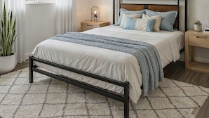 A bedroom with a bed, bedside tables, a nightstand, a potted plant, and a window with curtains. - Private Room in SE Austin - 10 min from Airport & Downtown (Austin)