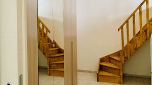Una escalera de madera con barandilla que sube a un piso superior.