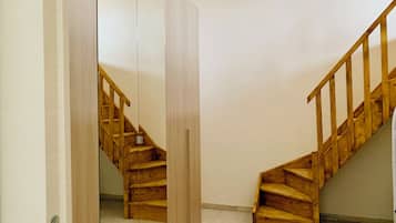 A wooden staircase with a handrail, leading to an upper floor.
