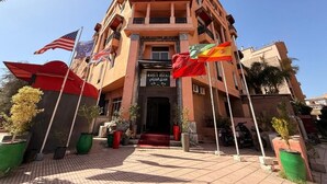 A multi-story building with a sign reading "HARTI HOTEL" in English and Arabic.