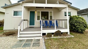 A single-story house with a front porch, a green door, and a sign reading "NANA'S CABANA." - Cozy 4BR Beach House Retreat (Bethany Beach)