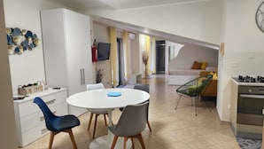 A compact living space with a kitchenette, dining area, and a bedroom.