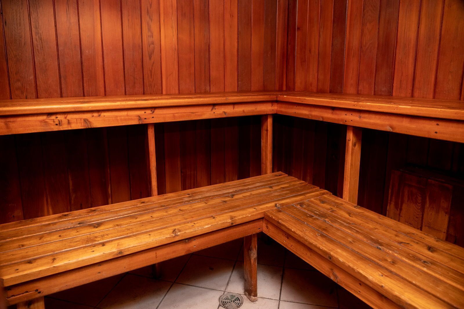 Un sauna avec des bancs et des murs en bois.