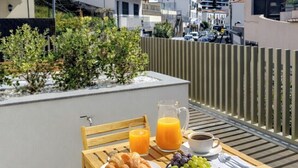 Ein Tisch mit Frühstücksangeboten auf einem Balkon mit Blick auf eine Hügelkette.