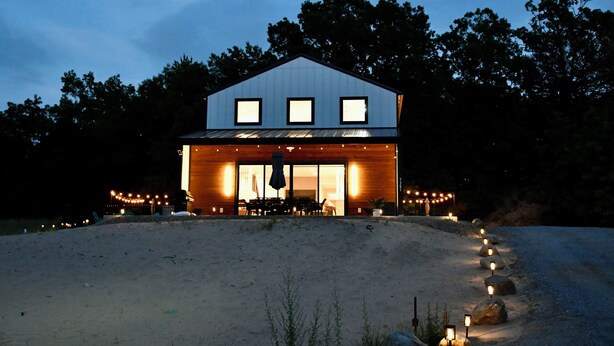 A modern house with a large front porch, a dining area, and a visible garage.