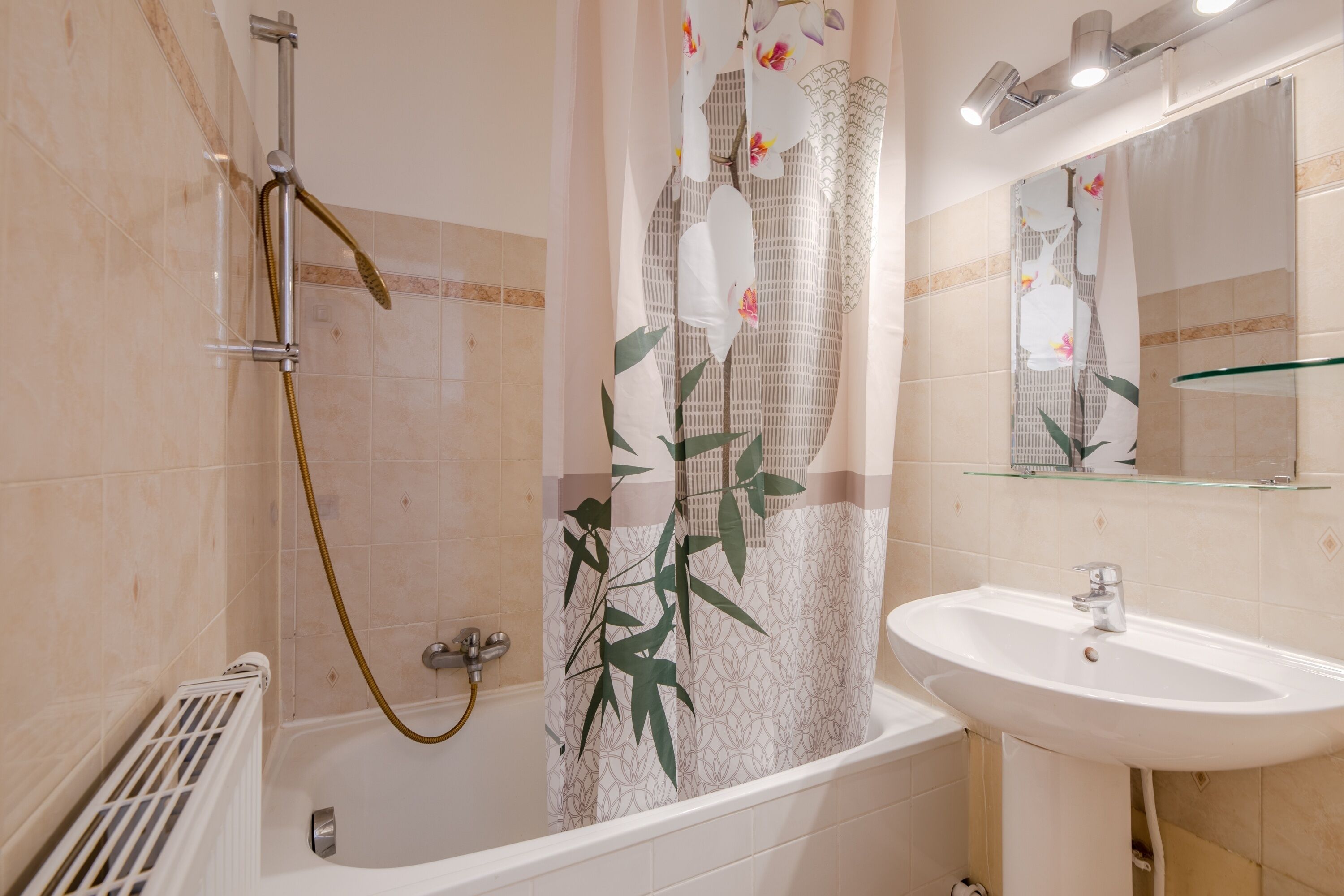 Een badkamer met een bad, douche en wastafel.