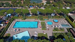 A large rectangular swimming pool surrounded by lounge chairs and umbrellas, with a smaller circular pool nearby. - Mobilhome im Ferienpark mit Grosser Poolanlage (Orbetello)