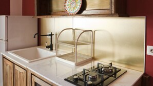 Una cucina con un piano di lavoro bianco, un piano cottura a gas, mobili in legno e una bacheca da bersaglio al muro.