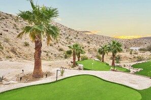 A desert golf course with multiple holes, palm trees, and a clear sky.