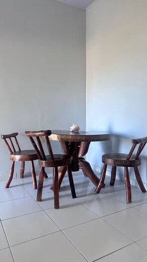 Un coin repas avec une table ronde et quatre chaises en bois.