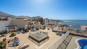 A rooftop terrace with sun loungers, a pool, and a view of the sea. - Ocean View La Caleta (La Caleta)