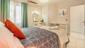 A hotel room with a bed, a desk, a chair, an air conditioning unit, a mirror, and a door. - Ocean View La Caleta (La Caleta)