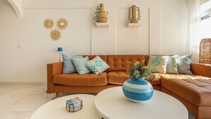 A living room with a brown sofa, two white coffee tables, and decorative items on the wall. - Ocean View La Caleta (La Caleta)