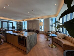 A modern hotel lobby with a marble island, leather seating, and large windows offering city views. - Live the Miami Experience | Prime Location Suite (Miami)