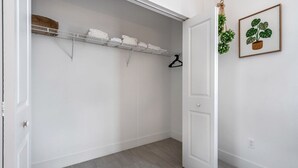 Ein begehbarer Kleiderschrank mit Regalen, einer Kleiderstange und einer Tür.