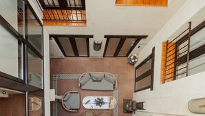 A modern interior with a sofa, a small table with a plant, and a decorative wall piece. - Suite Torre del Oro Seville: Pool, Balcony & AC in El Arenal (Sevilla)